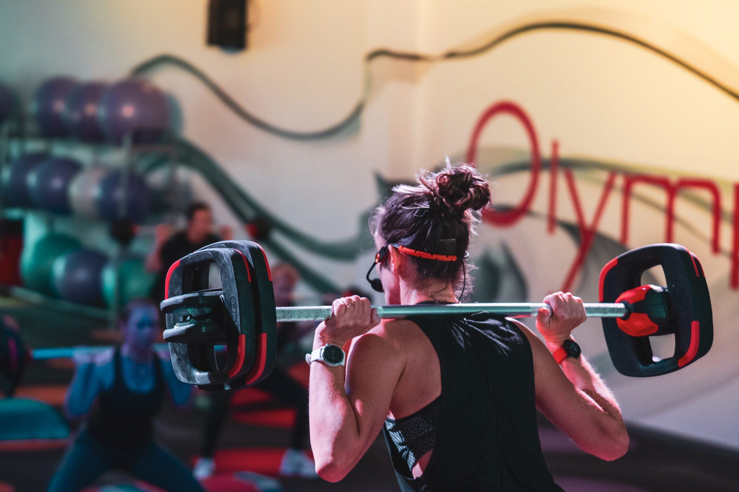 Une femme réalisant un exercice de fitness pendant un cours de TRX à Olympe fitness