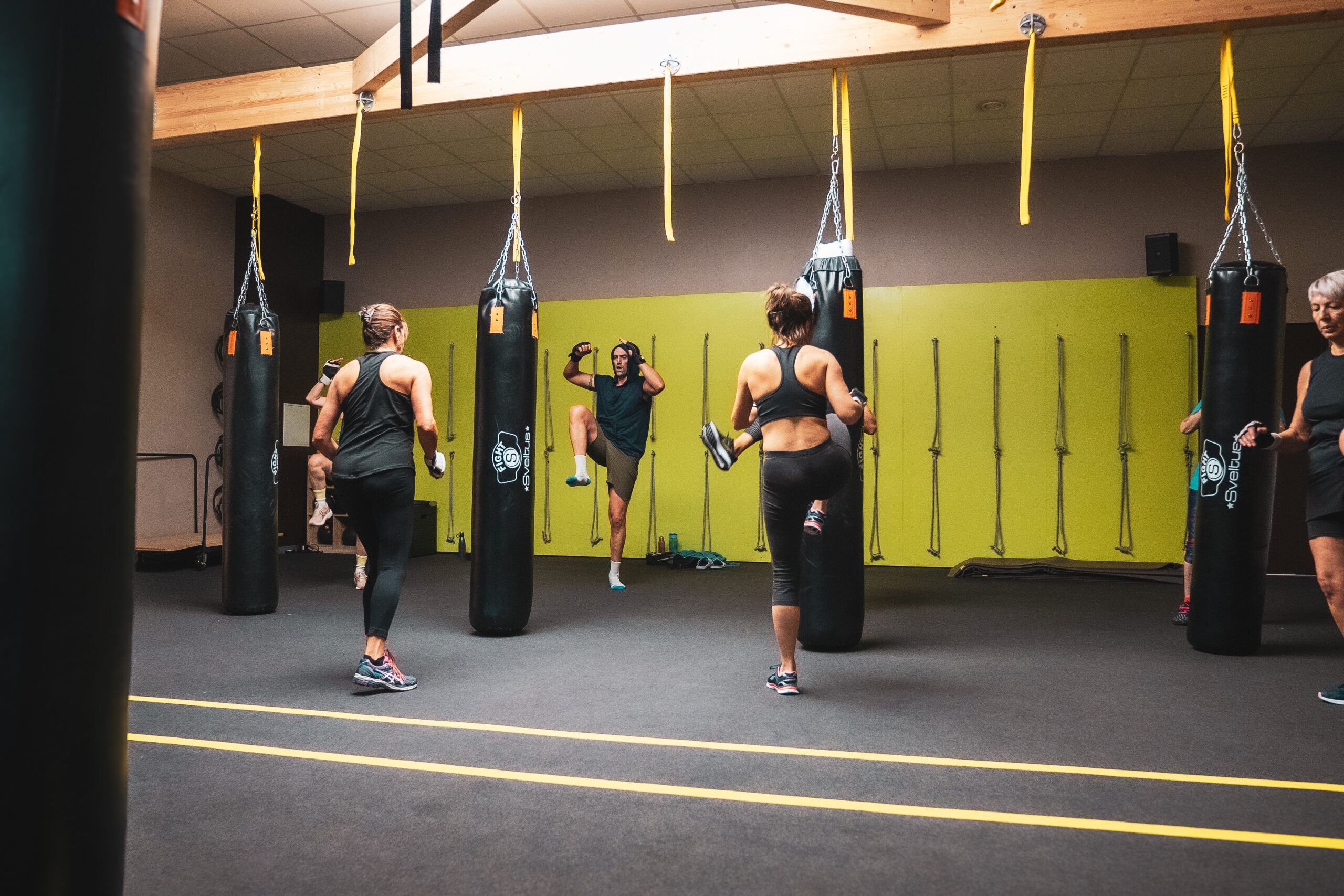 Deux femmes participants à un cours de boxe collectif animé par une coach à olympe fitness